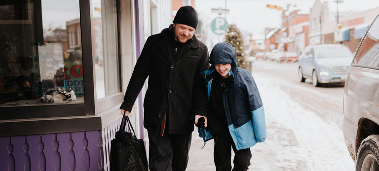 Father and son walking past shop in winter